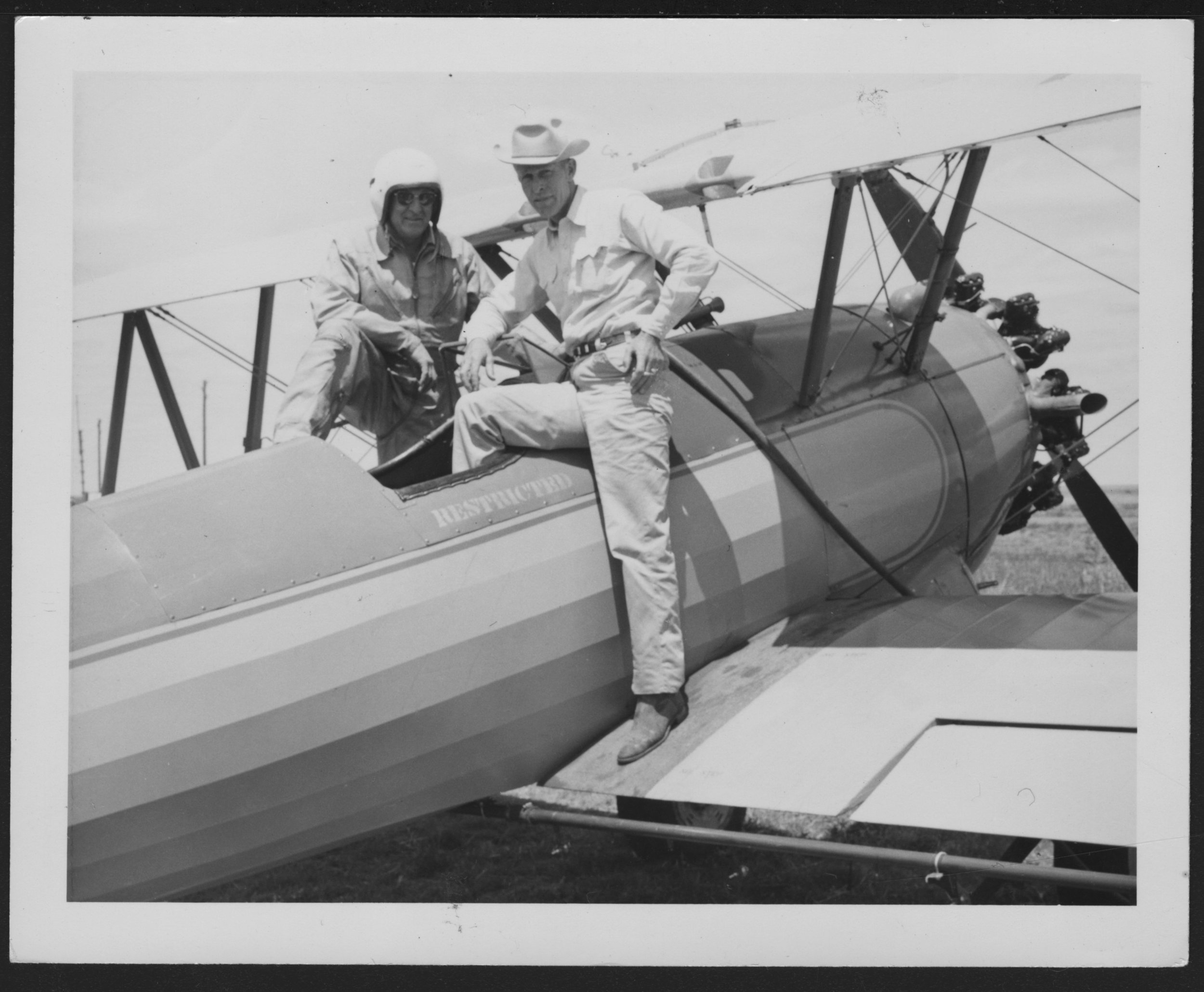 Grassland Ag pilots and weed scientists often worked together to address agricultural perils involved with pesticides and mitigate risks. In this late 1950s photograph, Dodge City spray pilot Roy Mahon can be seen in discussion with local weed super…
